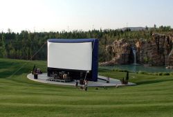 Open Air Cinema at Thanksgiving Point, with a small lake and waterfall in the background.