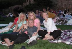 Moviegoers sitting on a lawn blanket at an Open Air Cinema event. - , Utah