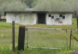 Graffiti covers the front of the Ranch Drive-In's projection building.  On the right side of the building's doorway are two sets of projection windows.