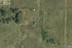 The small building in the center of this photo may be the ticket booth for the Ranch Drive-In.  Near the bottom of the photo are two rows of dots that probably show where the supports for the screen tower anchored into the ground. - , Utah