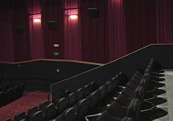 The smaller theaters at the Redstone 8 Cinemas have about 85 seats and 32-foot wide movie screens.  The theater auditoriums are decorated with red drapes, seats, and carpet. - , Utah