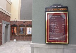 A 'Now Showing' poster case for the Redstone Cinemas lists all the movies an their showtimes. - , Utah