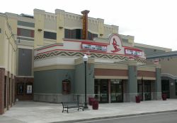 The front of the Redstone 8 Cinemas features a vertical sign with the name of the theater.  The small plaza in front of the entrance lamp posts and park benches. - , Utah