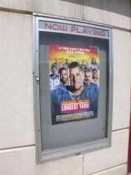 A 'Now Playing' poster case on the left of the theater entrance. - , Utah