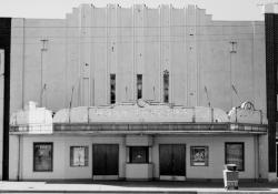 'Front facade is the best example of Art Deco style in Brigham City. . .   Strong vertical features in upper front facade include lighting fixtures and three vertical rows of small windows.  Lower facade is ceramic tile (yellow with green and blue trim); upper facade is painted light green.  Most remarkable feature is 'Roxy' marquee.'