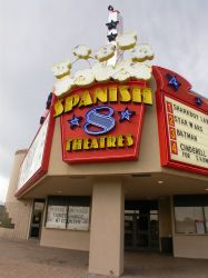 The sign of the theater is a popcorn bucket with the name 'Spanish 8 Theatres' written on it in neon letters. - , Utah
