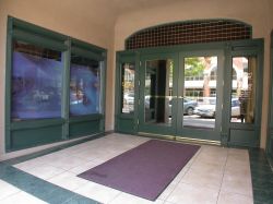 The entrance of the former theater has a tiled floor with windows into shops on either side and a set of doors at the end. - , Utah