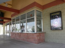 The ticket booth has four ticket windows.  A single poster case is on the right and the entrance doors on the left. - , Utah