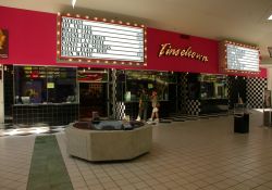 The entrance of the Cinemark Tinseltown theater is inside the Newgate Mall in Ogden, Utah.  The theater has three ticket booths with two ticket windows each.  Above them is the name of the theater, 'Tinseltown', with attraction boards on either side. - , Utah