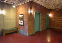 At the bottom of the stairs is a bench, a poster case, and two elevators. - , Utah