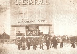 A group of musicians appear in front of the Willard Opera hall on Christmas Day, about 1890.  Some membersof the band are seated on a sleigh pulled by four horses. - , Utah