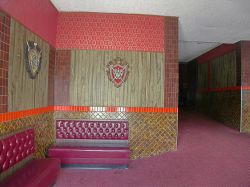 Looking through the exit doors into the left side of the lobby.  Coat of arms decorate the walls of the theater lobby. - , Utah